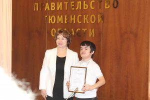 Заместитель губернатора Тюменской области Лариса Теплоухова награждает студента ТИУ Руслана Абдулина 